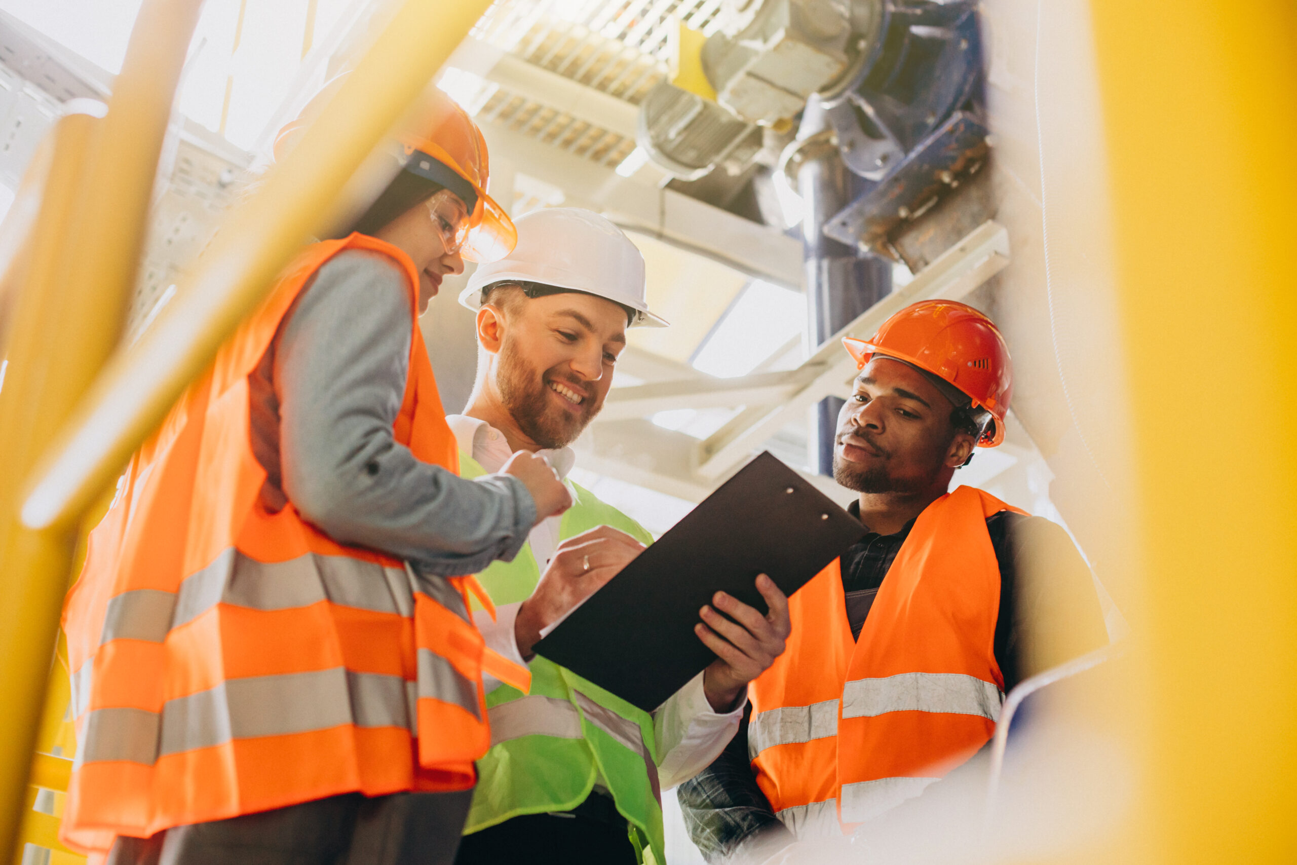 Three people discussing a safety plan at a factory